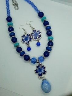 This beautiful set features blue and white flowers in the earrings and the main pendant of the necklace.  The necklace features different shades of blue beads to compliment the pendant. This is a great statement piece to set off any outfit and a must-have for women who want a unique necklace to show their personal style. Depending on the size, all jewelry comes shipped in either a box with cotton padding or wrapped carefully in tissue paper and mailed in a thick padded envelope to ensure it reac Pride Necklace, Blue And White Flowers, Pride Bracelet, Blue Acrylic Nails, Glass Beads Jewelry, Flower Pendant Necklace, Unique Necklace, Necklace And Earring Set, The Blues