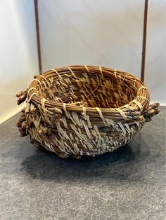 a wicker basket sitting on top of a gray counter next to a white wall