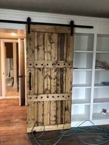 an open wooden door sitting inside of a living room next to a white book shelf