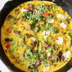 an omelet with meat and vegetables in a skillet