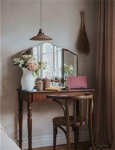 a small table with a mirror and vase on it