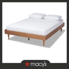 a bed with two pillows on top of it and the words macy's above it