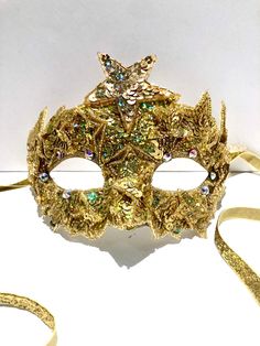 Solar system- Star masked ball- Halloween party- Old Hollywood  Hi.        This mask is made and is the one that will ship within 1 business day. The gold ab stars that have an iridescence to them.    The sequin stars are (1" wide)  and have a beaded edge. The stars cover the mask in various sizes. Mask measurements are 3"by 7" wide. The rhinestones are one the mask base around the eyes. One size fit most all adults. Star Colors: Silver  Gold Mix ----------------------------------- Plain $25. Matching MENS MASK: https://etsy.me/3WHxF2N Smaller headpiece version  Star https://etsy.me/2PoK39G   ---------------------------------------------- I've been making hair pieces over 20 years. I have so much fun creating these whimsical pieces. I love what I do, and I hope you do too!  I ship US Posta Star Mask Masquerade, Gold Masks And Prosthetics For Carnival Costume, Gold Fantasy Masquerade Mask For Party, Gold Fantasy Style Masquerade Mask For Party, Gold Masks For Carnival, Gold Costume Mask For Mardi Gras, Gold Masquerade Mask For Carnival Costume, Gold Masks And Prosthetics For Carnival, Gold Mardi Gras Costume Mask