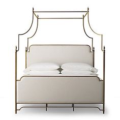 an iron bed frame with white linens and pillows on the headboard, against a white background