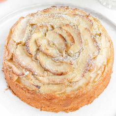 an apple cake on a plate with powdered sugar