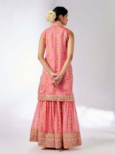 This pretty ensemble of floral jaal, with intricate border embroidery. The sleeveless kurta is embellished down the front and tried with a smart pleated magzi to finish the neckline and armhole. The flowing sharara bottom with gota embroidery still has a lot of flounce and flow. Sleeveless Kurta With Zari Work For Reception, Sleeveless Salwar Kameez For Eid Reception, Sleeveless Georgette Salwar Kameez For Reception, Traditional Sleeveless Salwar Kameez For Reception, Designer Sleeveless Dresses With Dori Work, Sleeveless Dresses With Dori Work, Designer Sleeveless Kurta With Dori Work, Sleeveless Anarkali Dress With Gota Work, Festive Sleeveless Dress With Gota Work