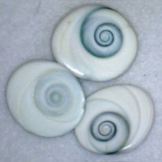 three white and blue buttons sitting on top of a table next to eachother