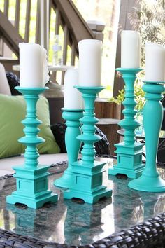 some candles are sitting on top of a glass table with blue and white decorations around it