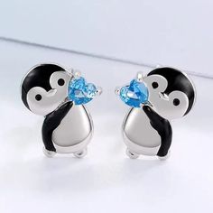 Please Look At Both Pics. The First Pic Has Been Touched Up For Clarity (Penguin Is Black And Silver, Not Black And White) Add A Touch Of Cuteness To Your Outfit With These Little Penguin Holding Blue Heart Stud Earrings. These Earrings Feature A Black And Silver Penguin Holding A Blue Heart, Perfect For Any Occasion. The Earrings Are Made Of Zinc Alloy And Have Silicone Push Back Closures, Ensuring They Stay Secure On Your Lobes. At Approximately 0.5 Inch From Top To Bottom, These Earrings Are Blue Heart Earrings, Penguin Earrings, Teardrop Silver Earrings, Club Earrings, Baublebar Earrings, Cute Penguin, 18k Gold Earrings, Heart Crystal, Mini Hoop Earrings