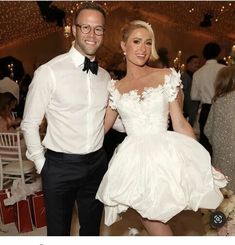 a man and woman in formal wear standing next to each other at a wedding reception