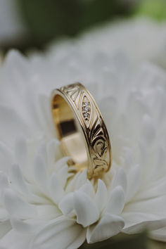 A 14K yellow gold mens' engagement band sits on a white chrysanthemum flower. This band features floral filigree details and three diamond accents. White Gold Engagement Rings For Men, Wedding Rings Engagement For Men, Nature Inspired Wedding Ring Men, Vintage Wedding Rings Mens, Custom Wedding Bands For Men, Mens Wedding Rings Unique Diamonds, Wedding Groom Ring, Unique Engagement Rings For Men Future Husband, Men’s Wedding Ring Diamond