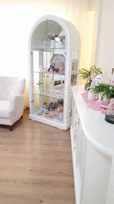 a living room filled with furniture and flowers on top of a hard wood floor next to a white couch