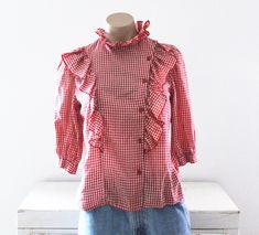 Vintage 70's gingham checked blouse.  Red and white cotton/polyester fabric.  Western, country girl styling.  Ruffled neckline and down the front.  Gathered shoulders.  Half sleeves. Condition: Good condition.  Slight piling on the fabric. Brand: Topson Downs Fabric: no fabric tag, feels like cotton/polyester Measurements: Taken flat, then doubled when necessary. Size tag: Medium Bust: 37 in. Waist: 35 in. Length: 21 in. Shoulders: 12 1/2 in. Sleeve length: 15 in. Checked Blouse, Cotton Polyester Fabric, Gingham Check, Fabric Tags, Country Girl, Country Girls, Vintage 70s, Half Sleeves, Womens Clothing Tops