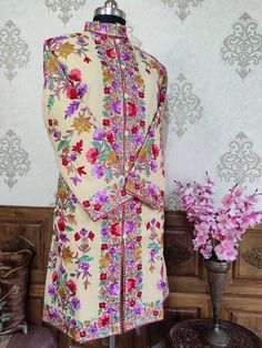 Kashmiri Jacket Women, Embroidery Jacket, Kashmiri Coat Get Customizable Kashmiri Jacket With Multi-colour Embroidery  A Long Woolen Kashmiri Jacket with All Over Multicolour Aari Embroidery (Front & Back) This Kashmiri jacket Makes you stand apart with its vivid colours and Floral embroidery, The base colour is Beige With  Multicolor Aari Embroidery is done all over the jacket, the material used is of high-quality Pure wool and the embroidery is done by brilliant Kashmiri artisans. Embroidery Designer Multicolor Nehru Jacket With Chikankari Embroidery, Festive Multicolor Nehru Jacket With Chikankari Embroidery, Designer Multicolor Bandhgala With Chikankari Embroidery, Fitted Bollywood Nehru Jacket With Multicolor Embroidery, Festive Multicolor Bandhgala With Chikankari Embroidery, Ceremonial Bandhgala With Floral Embroidery For Festivals, Fitted Nehru Jacket With Multicolor Zari Embroidery, Multicolor Sherwani With Chikankari Embroidery For Festivals, Traditional Fitted Outerwear With Floral Embroidery