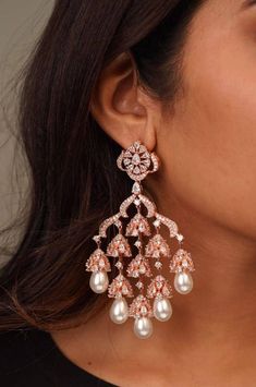 Stunning Fluttery CZ stones gives the right amount of sparkle you need for these gorgeous chaandbali earrings With Pearl hangings  Available in Rose Gold/Silver Polish Length: Approx 3.5 inches Lightweight Closure: Pushback Customized orders takes 3 to 4 weeks, depending on piece requirements. The Ombre Designs Jewelry pieces can be customized in accordance with your requirement. Please Email or Whats app on : +91 8448833193 / sonalikamehra [!at] theombredesigns.com Rose Gold And Pearl Earrings, Luxury Bollywood Pearl Earrings With Latkans, Luxury Elegant Earrings For Diwali, Luxury Festive Pearl Earrings With Latkans, Luxury Kundan Bollywood Chandelier Earrings, Luxury Chandbali Danglers For Party, Luxury Yellow Gold Chandbali Pearl Earrings, Luxury Chandbali Earrings For Reception, Luxury Festive Tilla Chandbalis