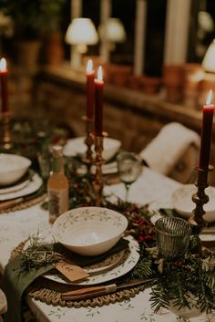 the table is set with candles and plates