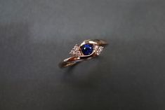 Product Specifications: - 4mm High quality natural Blue Sapphire at the center - 6 Round Brilliant cut Diamonds, total carat around 0.09ct - D-F in color and VS in clarity with Heart and Arrow (Ideal cut) - 18K Rose gold - Ring Width: 2.3mm Currently made to order pieces may take up to 10-15 business days to complete, or contact me if you need it in urgent. It's easy to create jewelry that's perfect for you. Change the materials to suit your style and budget: Diamond, Ruby, Emerald, Blue sapphir Rose Gold Round Cut Sapphire Ring, Rose Gold Sapphire Ring With Round Cut, Tension Engagement Rings, Tension Ring, Rose Gold Wedding Jewelry, Emerald Blue, Engagement Ring Unique, Unique Women, Ring Sapphire