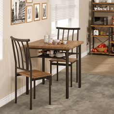 a dining room table and chairs with pictures on the wall