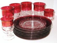 a set of red glass dishes and glasses