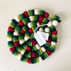 a clock made out of wool with red, green and white pom - poms