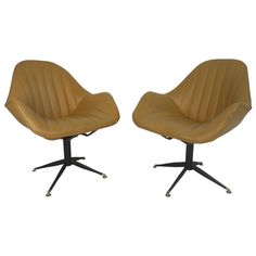 pair of mid century modern swive chairs in tan leather and castors, circa 1950