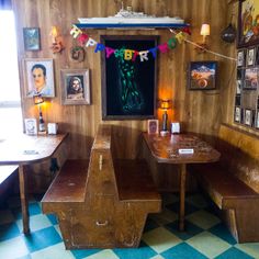 a room with two benches and pictures on the wall above it, along with other decorations