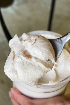 a person holding a spoon full of ice cream