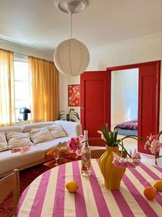 a living room filled with furniture and flowers in vases on top of a table