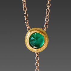 A brilliant rose cut emerald shines within a warm 22k gold wrapping, backed in solid gold, and stationed on a delicate 16 inch, 14k gold chain. The luminous gem is accented with a tiny 22k gold drop that hangs 1 inch below creating a lovely movement. A truly magical piece. Emerald pendant measures approximately 1/4 inch in diameter. Matte finish. This piece will be made to order, and will ship within 10-14 business days. If you need it sooner, use the Notes section on the order form to request a Gold Briolette Birthstone Necklace In Fine Jewelry Style, Gold Emerald Necklace With Delicate Chain, Fine Jewelry, Gold Briolette Birthstone Necklace Fine Jewelry, Fine Jewelry Gold Emerald Necklace With Delicate Chain, Gold Briolette Birthstone Necklace, Emerald Necklace With Delicate Yellow Gold Chain, Gold Emerald Necklace With Adjustable Chain, Yellow Gold Emerald Necklace With Delicate Chain, Gold Emerald Necklace With Adjustable Chain For Formal Events