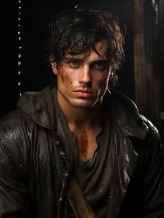 a young man with blood on his face and leather jacket, standing in front of a dark background