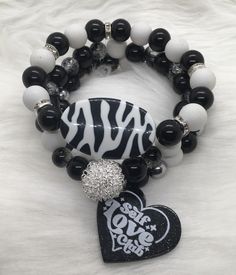 Three 7.5 inch bracelets with black and 10mm beads, large silver wire accent  bead, black and white oval accent bead and a heart shaped Self Love Club charm. Bracelet Ideas Black And White, Black And White Beaded Bracelet Aesthetic, Handmade Black Novelty Beaded Bracelets, Adjustable White And Black Beaded Bracelets, Black And White Bracelets, Trendy Black Heart-shaped Beaded Bracelets, Self Love Club, Love Club, White Bracelet