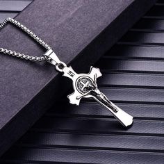 This classic religious pendant necklace is exceptionally made from high-class quality stainless steel that features a Christian designed pendant. Highly polished, to achieve the desired durability, perfect for all men who want attention. Elevate any of your trendsetting church attire by complementing it with a piece of highly polished jewelry like this. Focus on your fashion statement and be the star this season by wearing this glorious masterpiece.  Product highlights:   Perfectly detailed cros Father's Day Stainless Steel Cross Pendant Necklace, Spiritual Stainless Steel Necklaces For Father's Day, Spiritual Stainless Steel Necklace For Father's Day, St Benedict Cross, St Benedict Medal, Cross Medal, Benedict Medal, Necklaces For Men, Cross Wall