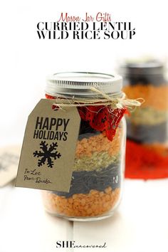 a jar filled with colorful food next to a tag on the lid that says happy holidays