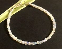 A beautiful and luminescent bracelet made with genuine opal gemstones. The opals measure approximately 3mm in diameter, and they are AAA quality welo opals imported from Ethiopia. This is made to order in the length of your choice, and is available from 6-9 inch lengths. To ensure for a great fit, the best way to determine your size is to wrap a piece of string around your wrist and then measure that string. The length you choose will be the total measurement from tip-to-tip. You have the option Small Gift Boxes, Opal Bracelet, Welo Opal, Opal Gemstone, Ethiopia, Artisan Jewelry, Silver Beads, Bracelet Making, Small Gifts