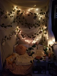 a bed with lights strung over it and stuffed animals on the bed in front of it