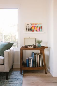 a living room with a couch, coffee table and bookshelf in front of a window