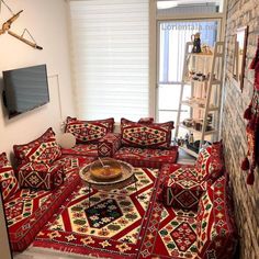 a living room filled with red couches and rugs