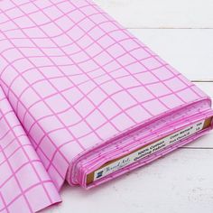 a pink binder sitting on top of a white wooden floor next to a book