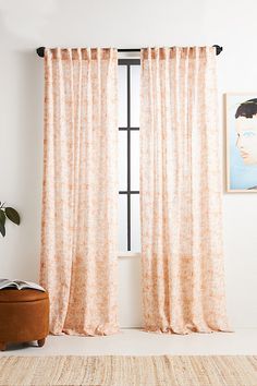 a living room with a rug, window and painting on the wall