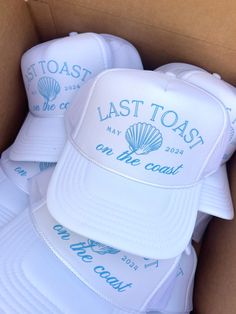 white caps in a cardboard box with the words last toast printed on one side and blue lettering on the other