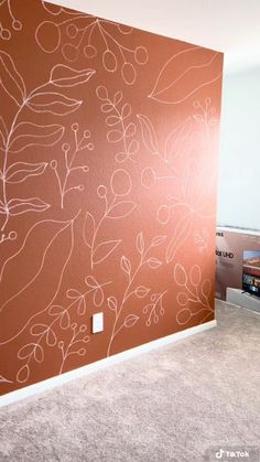 an empty room with a painted wall in the corner and carpet on the floor next to it