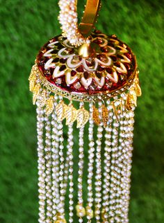 Traditional Indian bridal jewelry does not just carry stories of cultural value. But, also adds a touch of elegance to the bride's outfit. Gold-plated Kalira bangle jewelry comes with cluster pearl bands. Red Meenakari work accents this Kaleereh adding color to this bride's jewelry. Multiple leaf-like metal carvings adorn this Kaleera, making it the perfect piece for your Indian Kalire ceremony. Strands of mini-pearl hangings further elaborated with Butta jewelry at the bottom make it one of a k Bridal Jewellery Indian, Bride Clothes, Bangles Jewelry, Bride Jewellery, Indian Bridal, Bridal Outfits, Exquisite Design, Indian Jewelry, Bridal Wear