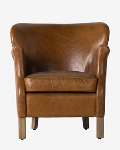 a brown leather chair sitting on top of a white floor