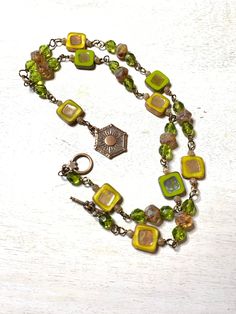 Beautiful necklace made of green and yellow and brown czech glass beads. It is wire wrapped with bronze wire and measures approximately 24 1/2 inches in length with the pendant dangling an additional 3 inches. The pendant is a copper plated pewter made by Tierra cast. It closes with a toggle clasp. Czech Glass Necklace, Yellow Necklace, Dragonfly Earrings, Jasper Necklace, Bird Earrings, Copper Plated, Green And Yellow, Moon Pendant, Beautiful Necklace