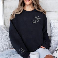 Embrace witchy charm with our Embroidered Bat Sweatshirt with bats on the sleeve too!. This goth-inspired, witchy delight features beautifully stitched celestial bats. A must-have for alt fashion lovers seeking a touch of whimsigoth clothing. Comfortable, stylish, and perfect for women who adore horror-inspired fashion. Check out more Halloween/Thanksgiving items here: https://www.etsy.com/shop/GrumpyGooseApparel?ref=seller-platform-mcnav&section_id=40090396 Browse through my other awesome items Spooky Black Long Sleeve Sweater, Spooky Long Sleeve Black Sweater, Black Cotton Halloween Sweater, Gothic Long Sleeve Halloween Tops, Gothic Long Sleeve Tops For Halloween, Black Gothic Sweater For Halloween, Halloween Grunge Long Sleeve Sweater, Black Long Sleeve Top For Halloween, Long Sleeve Black Top For Halloween