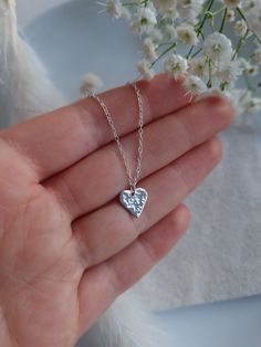 This dainty heart necklace is handcrafted and hammered to catch the light beautifully.  DETAILS: - Made with recycled sterling silver, suspended from a delicate trace chain, also made from recycled sterling silver.  -Pendant measures approximately 1cm (it is very dainty). - The necklace modelled is on a 16 inch chain. Please get in touch with any questions about sizing.  Each pendant is made by hand and so please allow for slight variations in shape and texture. POSTAGE AND PACKAGING: Your item will be gift wrapped in a small reusable cotton organza bag (perfect for gifting!) in 100% recyclable eco-friendly tissue and box and posted first class. All items are posted using Royal Mail first class (UK). Jewellery care:   To keep your silver sparkling, please avoid direct contact with oils/ lo Minimalist Sterling Silver Heart Necklace For Mom, Hammered Sterling Silver Charm Necklace As Gift, Dainty Handmade Sterling Silver Heart Necklace, Tiny Heart Shaped Silver Necklace, Everyday Silver Nickel-free Heart Necklace, Heart-shaped Hammered Sterling Silver Jewelry, Nickel-free Silver Heart Necklace For Gift, Minimalist Heart-shaped Sterling Silver Charm Necklace, Tiny Heart-shaped Silver Necklace