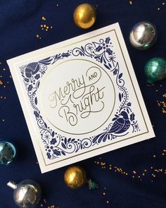 a merry and bright greeting card surrounded by christmas ornaments on a blue background with gold confetti