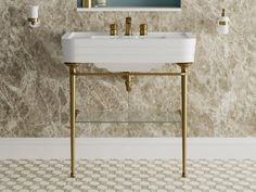 a white sink sitting under a mirror next to a wall mounted faucet in a bathroom