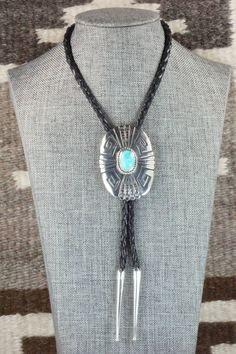 This turquoise and sterling silver bolo tie was made by Navajo silversmith Rosita Singer. The back is signed T&R Singer and stamped sterling.Tie Length: 22 1/4"Length: 2 3/8"Width: 1 3/4"Tips:Length: 2 1/8"Width: 1/4"Free shipping on all orders! We ship with USPS and always include tracking. All orders ship within a day of payment.Returns are accepted up to 30 days after you receive your order. Just send us a message. Our shop offers cash back or store credit. The item must be returned in new co Southwestern Sterling Silver Bolo Tie As Gift, Southwestern Bolo Tie With Sliding Knot, Southwestern Adjustable Lariat Turquoise Necklace, Southwestern Lariat Turquoise Necklace, Southwestern Adjustable Turquoise Lariat Necklace, Adjustable Southwestern Turquoise Lariat Necklace, Artisan Silver Lariat Bolo Tie, Adjustable Southwestern Silver Turquoise Necklace, Southwestern Lariat Bolo Tie For Rodeo