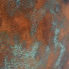 a close up view of an old metal plate with blue and orange paint on it